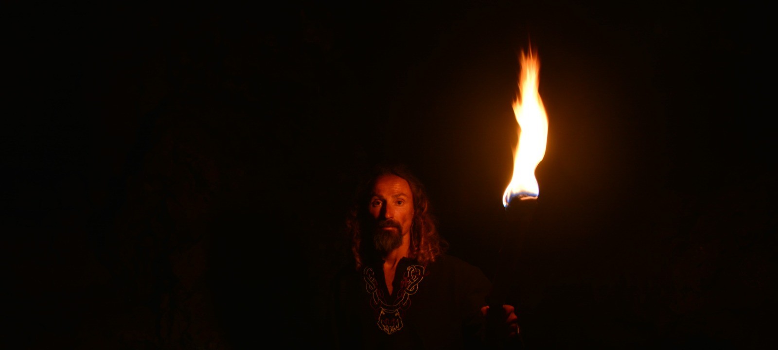 Retrato à luz de um archote, sobre fundo negro